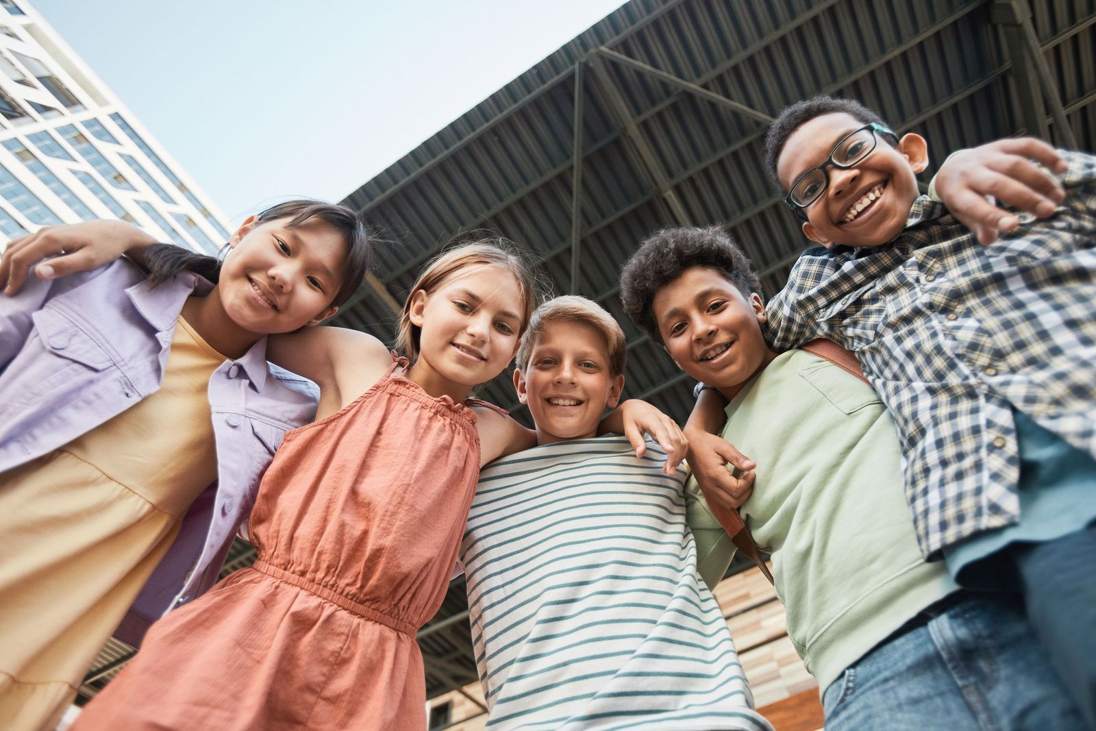 A group of smiling children with their arms around each other