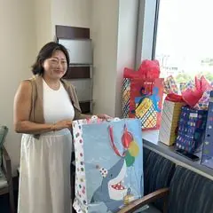 A volunteer holding a birthday gift bag