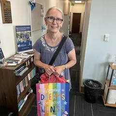 A volunteer holding a birthday gift bag