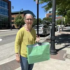 A volunteer holding a birthday gift bag